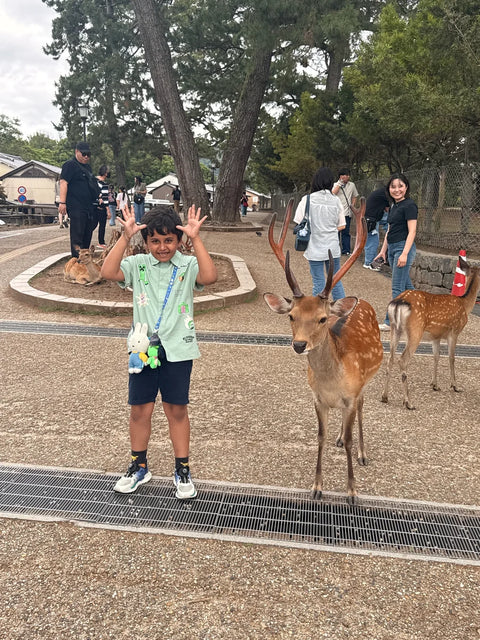 child posing with a deer in nara, japan on a beyond tokyo journey