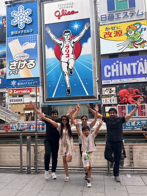 friends postin near glico sign, dotonbori, osaka, japan on a beyond tokyo journey